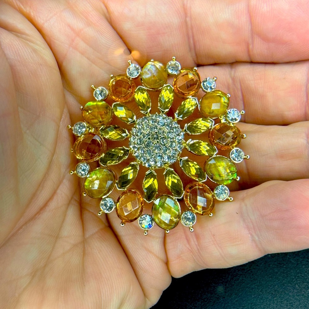 Woman’s vintage brooch. Brown and amber colored stones in a gold tone setting